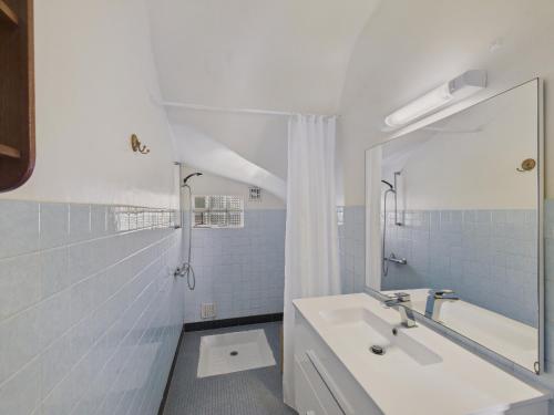 une salle de bain blanche avec un lavabo et une douche dans l'établissement La Frégate - Dans une chaumière pour 4 avec jardin, au Guilvinec