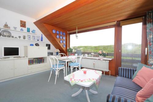 a kitchen and living room with a table and chairs at Feusser Dünenblick in Wenningstedt