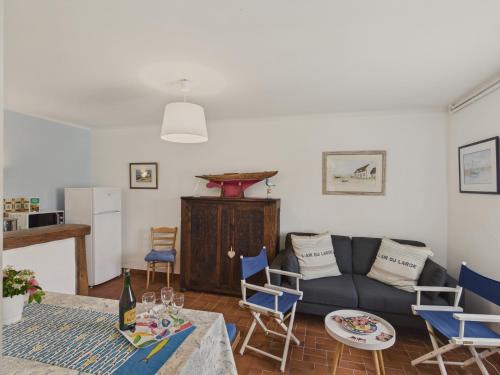 un salon avec un canapé, une table et des chaises dans l'établissement Le Vaisseau - Pour 4 avec jardin dans une chaumière, au Guilvinec