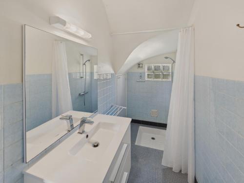 une salle de bain blanche avec un lavabo et une douche dans l'établissement Le Vaisseau - Pour 4 avec jardin dans une chaumière, au Guilvinec