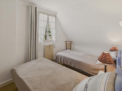 une chambre avec deux lits et une fenêtre dans l'établissement Le Vaisseau - Pour 4 avec jardin dans une chaumière, au Guilvinec