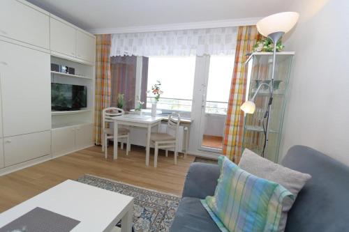 a living room with a blue couch and a table at Haus Metropol, App. 172 OB in Westerland (Sylt)