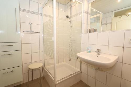 a white bathroom with a sink and a shower at Haus Metropol, App. 172 OB in Westerland (Sylt)
