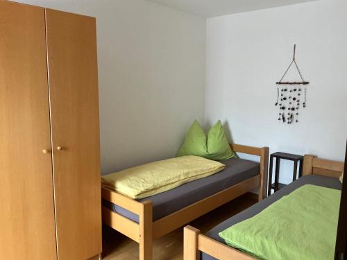 a small room with two beds with green sheets at Halleinerhaus by Soul Rebels in Größing