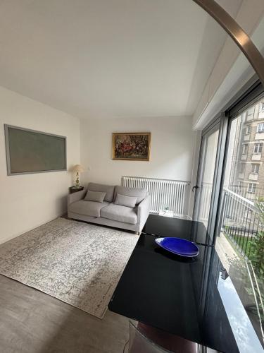 un salon avec un canapé et une grande fenêtre dans l'établissement Appartement Suffren Champs de Mars, à Paris