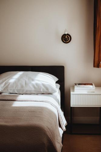 a bedroom with a bed and a side table at Pensjonat Witoldówka in Krynica Zdrój
