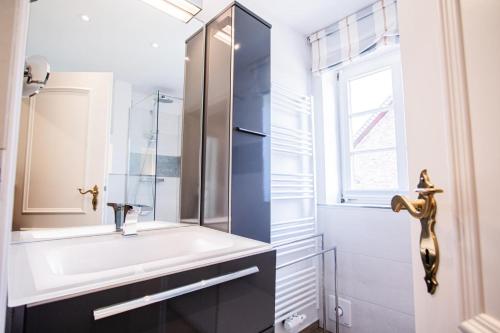 a bathroom with a sink and a window at Haus Munkhoog in Munkmarsch