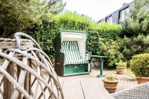 a green and white chair sitting on a patio at Haus Munkhoog in Munkmarsch