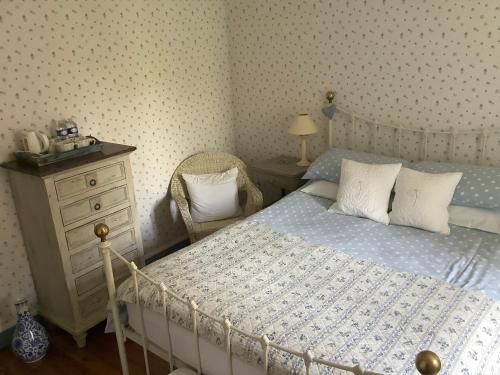 a bedroom with a bed and a dresser with a telephone at Chambres d'Hôtes Belle Vallee in Domfront