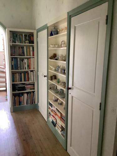 a room with a book shelf with books at Chambres d'Hôtes Belle Vallee in Domfront
