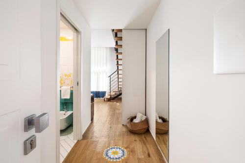 a hallway with white walls and a staircase in a house at YourHome - Lidia Rooms & Suites in Sorrento