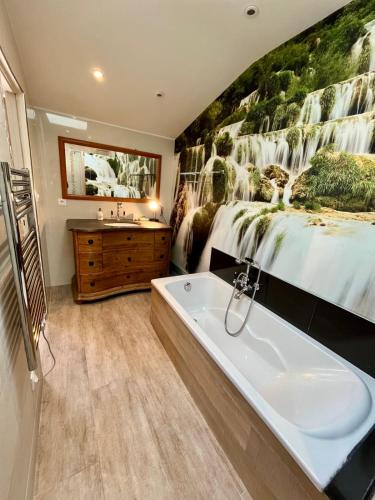 - une salle de bains avec un lit et une baignoire à côté d'une chambre dans l'établissement L'Hermione - Room in the heart of St Martin de Ré, à Saint-Martin-de-Ré