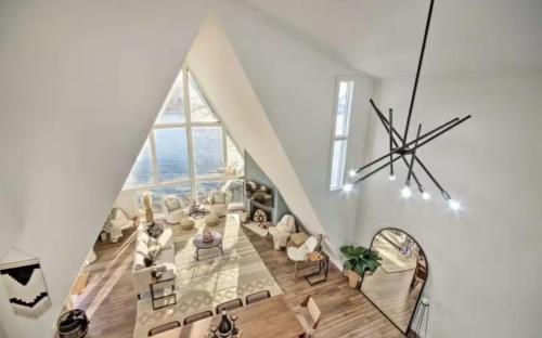 a living room with a staircase with a large window at Lakefront Hgtv Home-3bed3bathdockfirepit-12pp in Lake Ozark