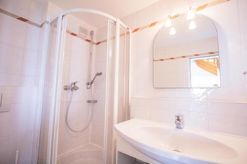 ein weißes Badezimmer mit Dusche und Waschbecken in der Unterkunft Alte Mühle in Keitum