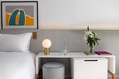 a bedroom with a bed and a table with a vase of flowers at Sofitel Agadir Thalassa Sea & Spa in Agadir