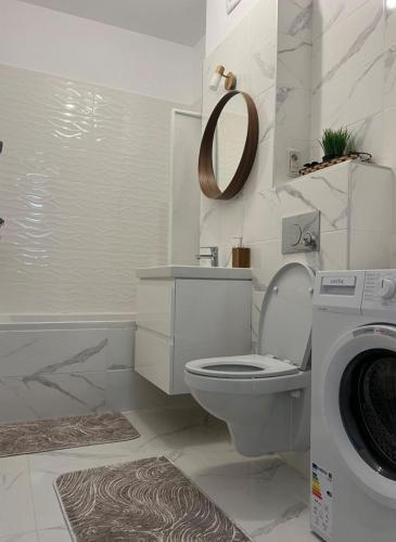 a bathroom with a toilet and a washing machine at Apartament sector 5 Sara in Bucharest