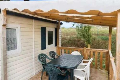 d'une terrasse avec une table, des chaises et une pergola. dans l'établissement Camping 3 étoiles - Piscine - efcagd, à Saint-Georges-de-Didonne