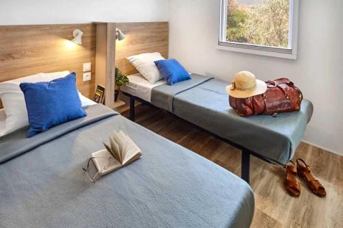 deux lits dans une chambre avec chapeaux et chaussures dans l'établissement Chalet 4 étoiles - efaaba, à Roquebrune-sur Argens