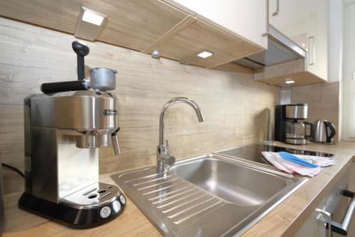 a kitchen with a sink and a mixer on a counter at Entennest am Dorfteich in Wenningstedt