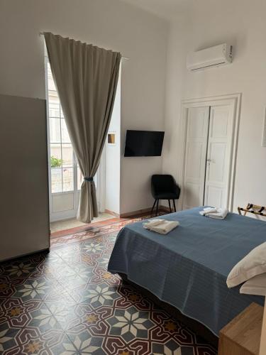 a bedroom with a bed and a chair and a window at Il Nido della Gioia Affittacamere in Trani