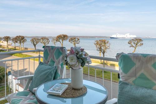 a table with a vase of flowers on a balcony at Villa Fördestrand Fender in Laboe