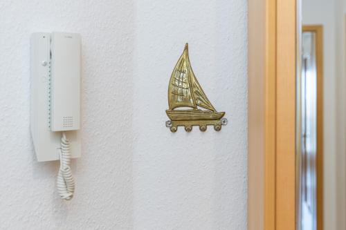 a drawing of a boat on a wall next to a phone at Villa Fördestrand Fender in Laboe