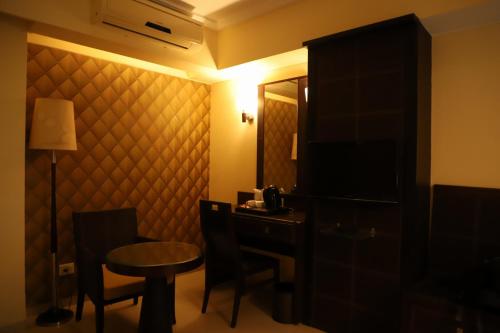 a hotel room with a desk and a table and a room at The Citiotel, Shivaji Nagar in Pune