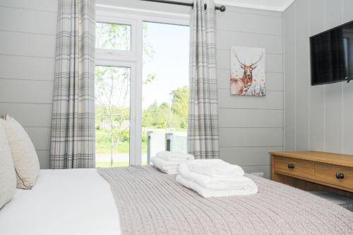 a bedroom with a bed with towels on it at 17 Meadow Retreat in Liskeard
