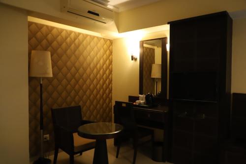 a room with a desk and a table and a mirror at The Citiotel, Shivaji Nagar in Pune