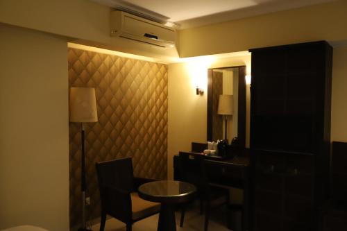 a room with a desk and a table and a mirror at The Citiotel, Shivaji Nagar in Pune