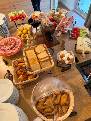 a table topped with baskets of bread and other food at Lux Apartment 14 in Kravlja