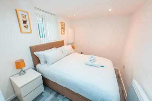 Un pequeño dormitorio con una cama con una toalla. en Sale 2-Bedroom Apt Sleeps 5 with Free Parking, en Sale