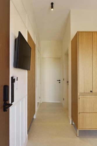 a hallway with a flat screen tv on a wall at Palm Boutique Suites in Pefkohori