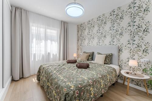 une chambre avec un lit avec un papier peint fleuri dans l'établissement Vista Magica Beachfront Suite, à Acantilado de los Gigantes