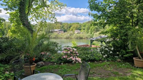 a view of a pond with chairs and flowers at 4 Sterne-Haus am See in Waren