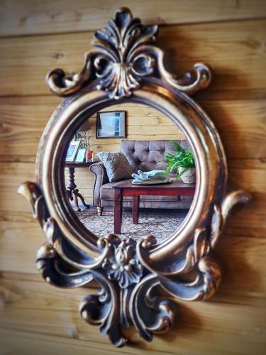 a mirror reflecting a living room with a couch at Casa Aristocrată - La noi la munte in Mătişeşti