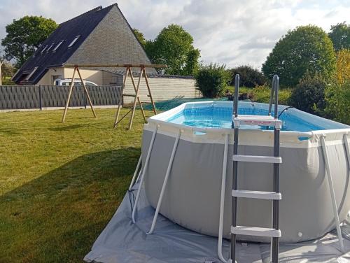 - une piscine dans une cour avec une échelle à côté dans l'établissement Family Home Between Land Sea Maison Familial Entre Terre et Mer Avec piscine, à Plédran