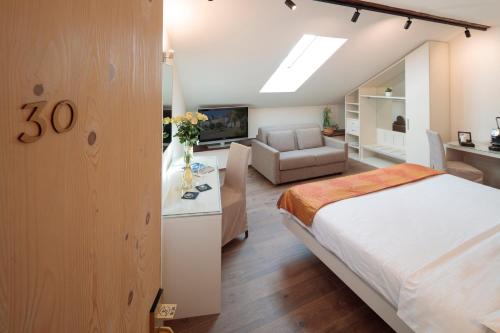 a bedroom with a bed and a living room at Hotel America in Locarno