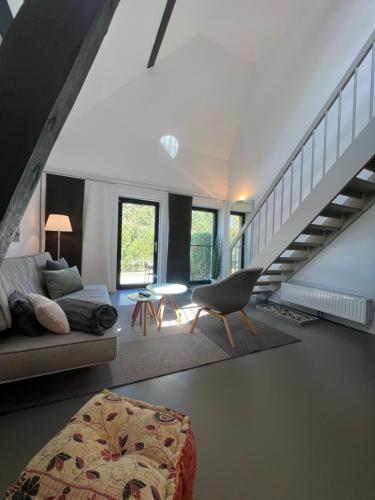 a living room with a staircase and a couch at HAUS DOHRMANN - mit direktem Strandzugang,moderne, ruhig gelegene Ferienwohnungen mit Terrasse in Binz