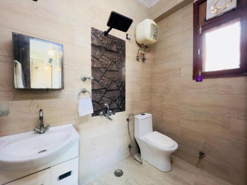 a bathroom with a toilet and a sink and a window at Marigold 5 Min Away Botanical Garden Metro in Noida