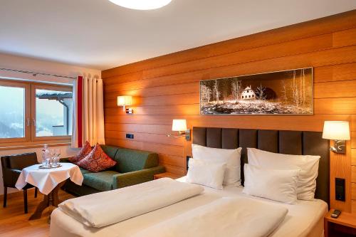 a hotel room with a bed and a chair and a table at Hotel Zinnkrügl in Sankt Johann im Pongau