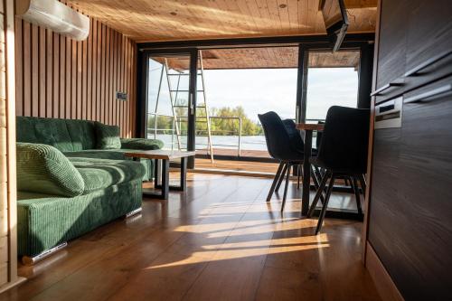 a living room with a green couch and a table at House Boat s výhledem na Wake Port in Brandýs nad Labem-Stará Boleslav