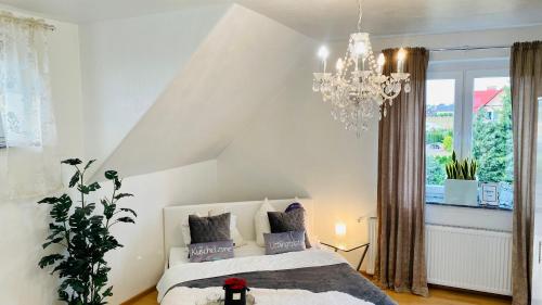 una camera da letto con un letto e un lampadario di VILLA SUNSHINE "SUNSHINE SUITE" NAD JEZIOREM KOMINEK i WANNA w SALONIE OGRóD BALKON a Lipnica