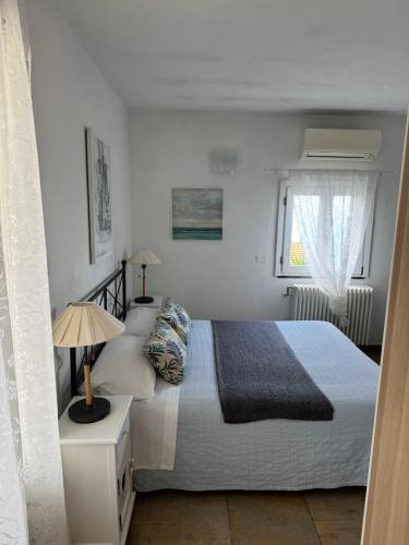 a white bedroom with a bed and a window at Affittacamere PZ in Vernazza