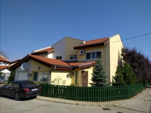 ein Haus mit einem davor geparkten Auto in der Unterkunft House with a garden in Pipera in Bukarest