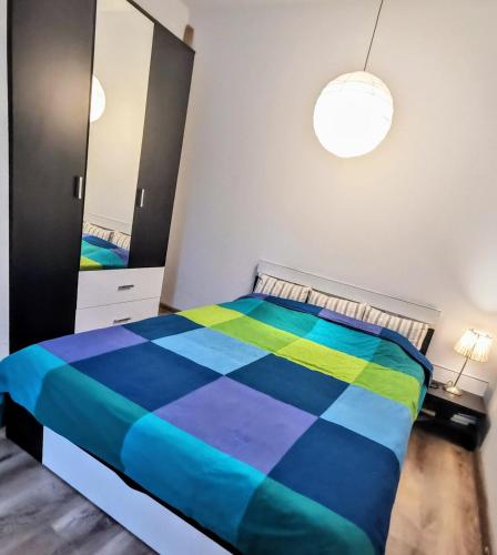 a bedroom with a colorful bed and a mirror at House with a garden in Pipera in Bucharest