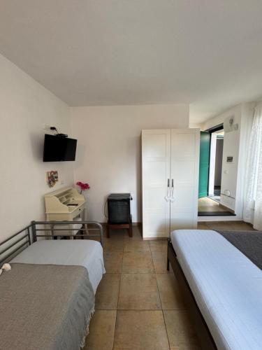 a bedroom with two beds and a desk and a television at Affittacamere PZ in Vernazza