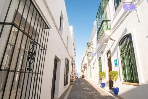 an alley in an old town with white buildings at Hostal Casa Alborada in Conil de la Frontera