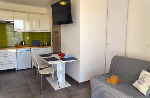 a kitchen with a table and a couch in a room at Apartmani Dalmacjia in Grebaštica