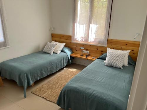 a room with two beds and a window at La Coma Sa Riera in Begur